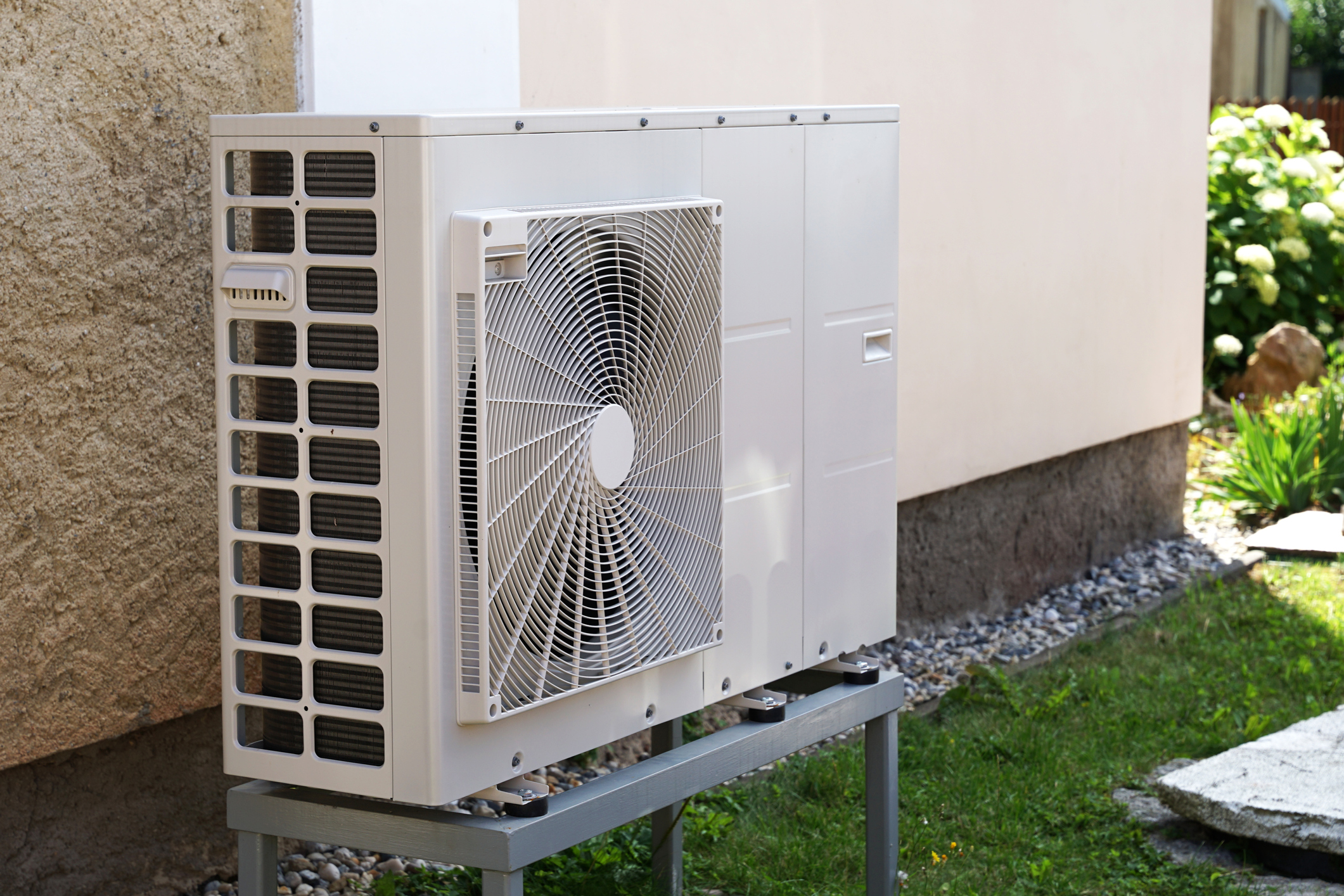 Heat pump outdoor unit against a modern house